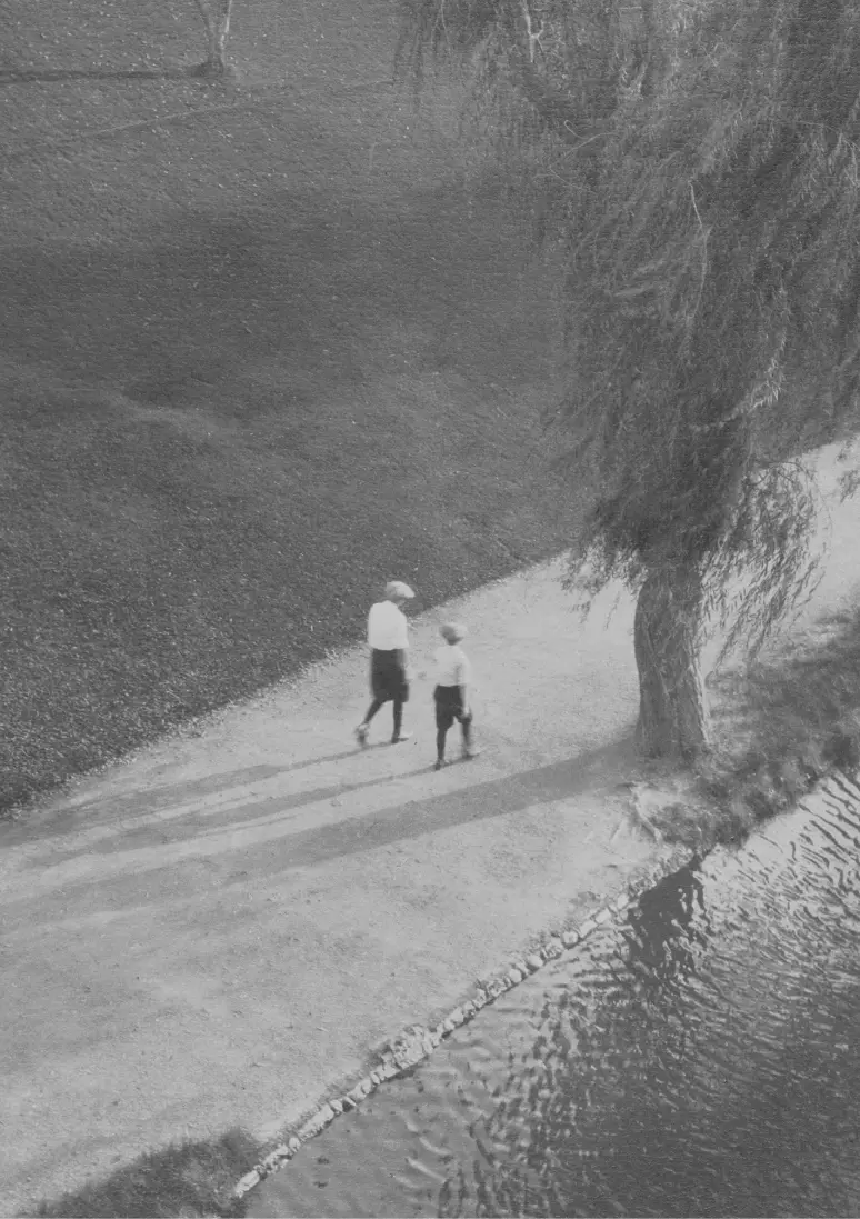 Černobílá fotografie zachycující ženu a dítě z dálky.